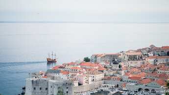 Luftaufnahme der Altstadt von Dubrovnik mit braunen Dächern am Meer in Kroatien