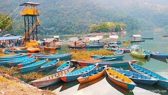 Pokhara, Nepal'da arka planda Annapurna dağ silsilesinin göründüğü Fewa Gölü'nde renkli tekneler